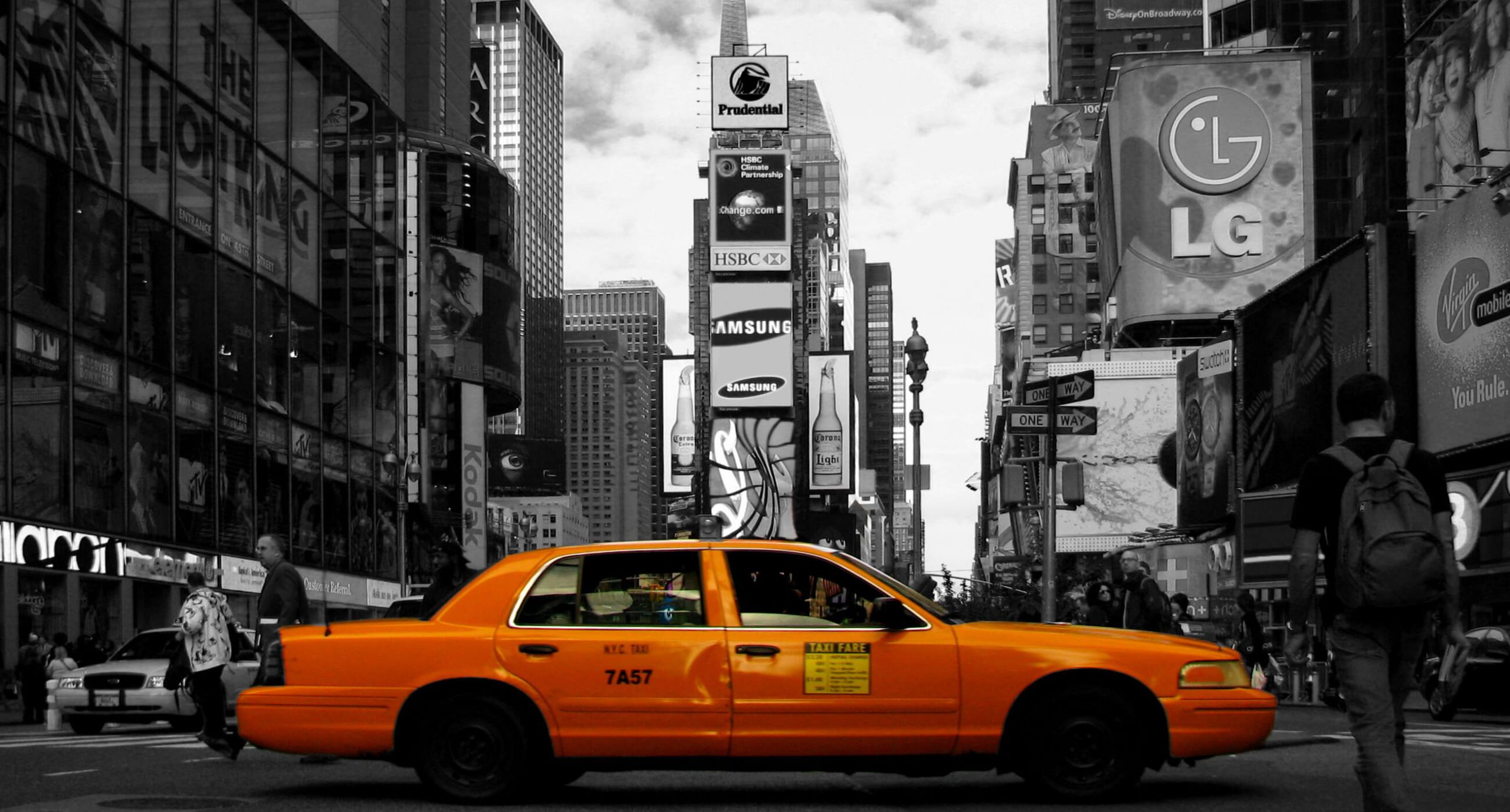 A yellow taxi drives through Times Square in New York. Soon, Uber will allow users to hail taxis from within its app.