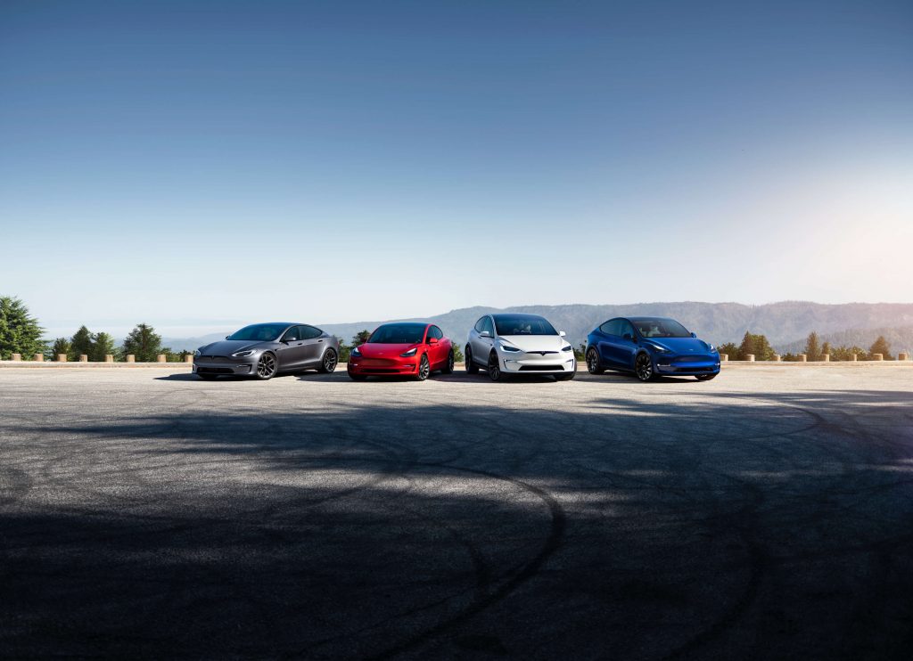 Photo depicting each of the Tesla models on offer, from left to right a silver Model S, a red Model 3, a white Model X, and a blue Model Y.