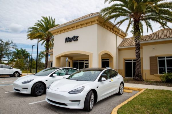 Photo of Tesla rental EVs in front of a Hertz retail location. Hertz and BP are teaming up to make charging these EVs easier.
