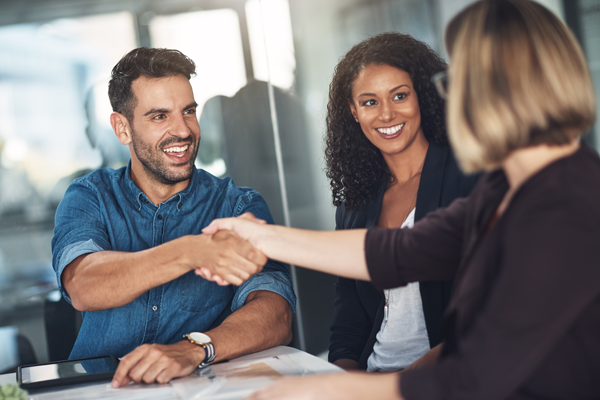 three adults negotiating happily at an office