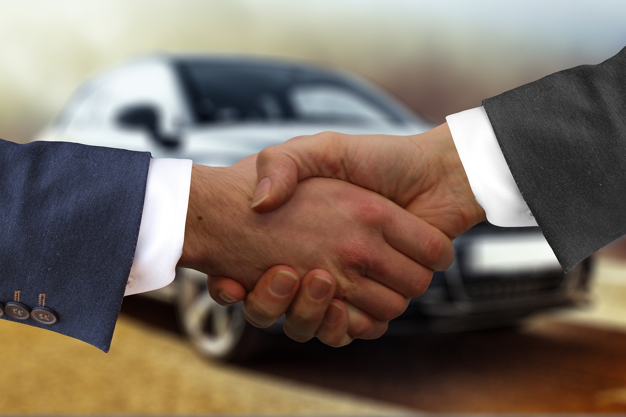 two people shaking hands after used car sale